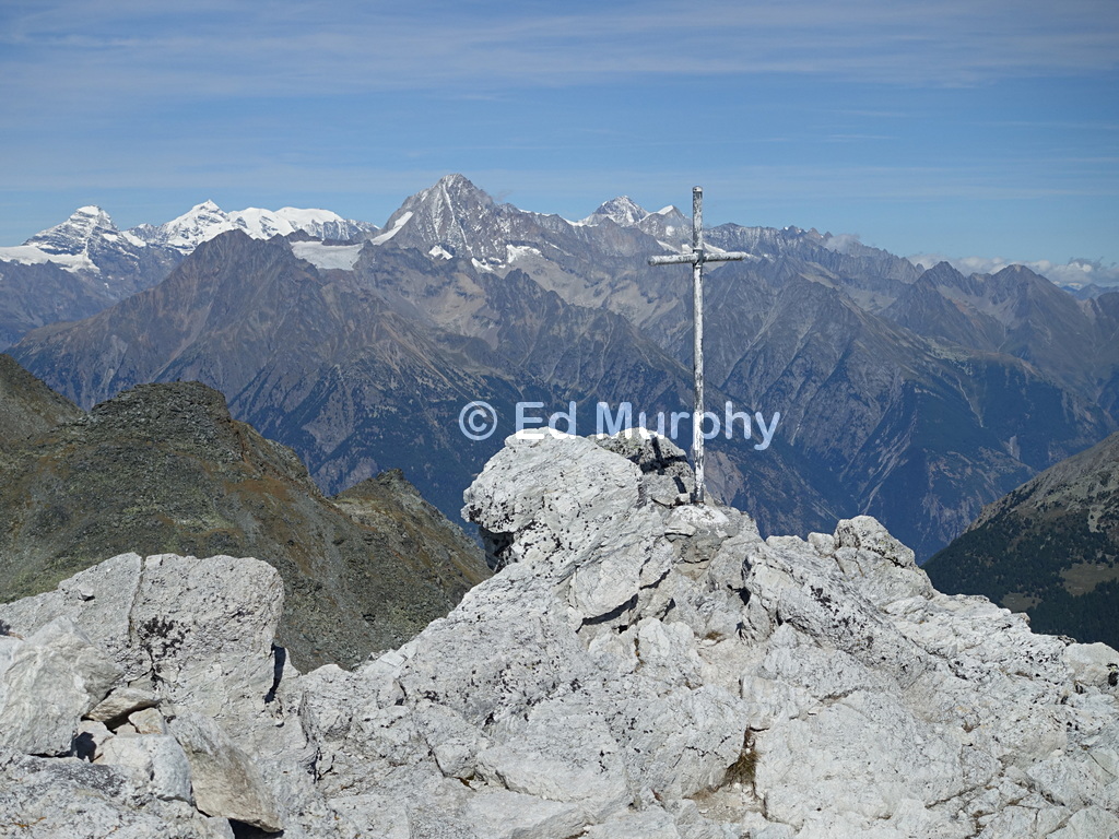 The Cabane Bella Tola's summit cross with a Bernese Oberland backdrop