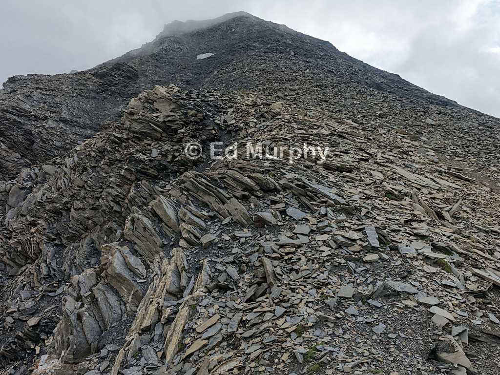 The long ascent over brittle slate to the summit of the Muttler