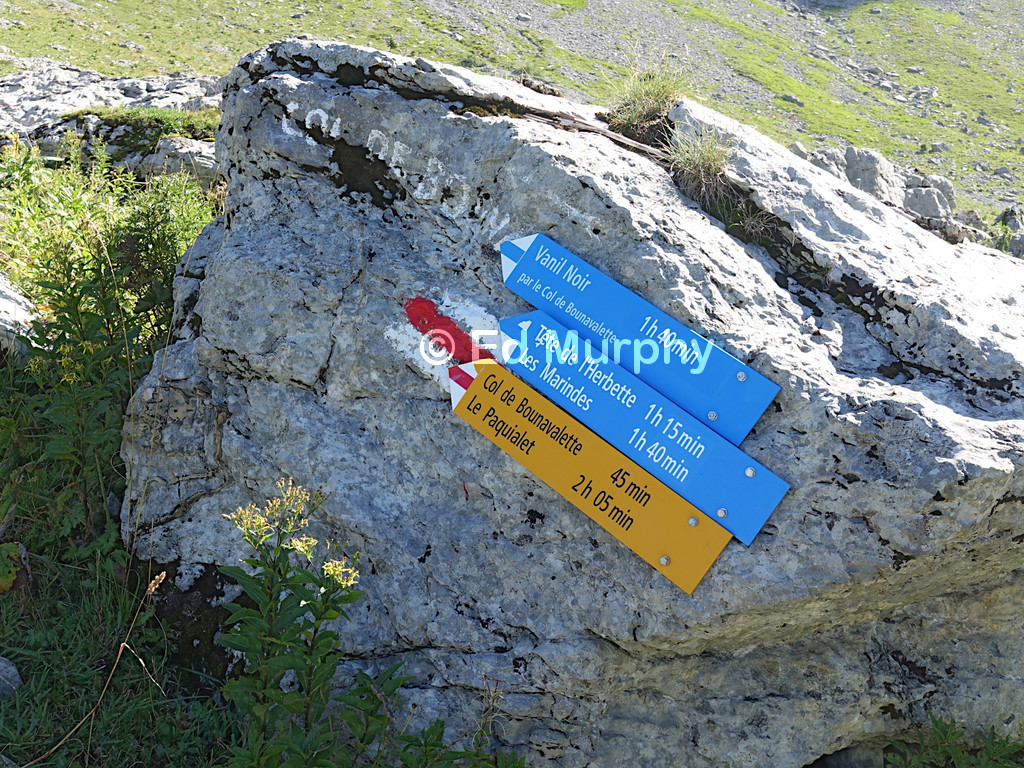 Blue signposts above the Bounavau Hut warn of difficulties ahead